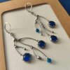 Asymmetrische handgemaakte takoorringen met blauw glas en zilverkleurig koper
