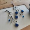 Asymmetrische handgemaakte takoorringen met blauw glas en zilverkleurig koper