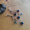 Asymmetrische handgemaakte takoorringen met blauw glas en zilverkleurig koper