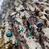 Asymmetrische handgemaakte takoorringen met groen glas en zwart gepatineerd koper