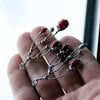 Asymmetrische handgemaakte takoorringen met rood glas en zilverkleurig koper