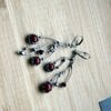 Asymmetrische handgemaakte takoorringen met rood glas en zilverkleurig koper