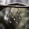 Asymmetrische handgemaakte takoorringen met transparant glas en zwart gepatineerd koper
