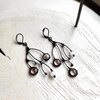 Asymmetrische handgemaakte takoorringen met transparant glas en zwart gepatineerd koper