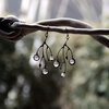 Asymmetrische handgemaakte takoorringen met transparant glas en zwart gepatineerd koper