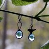 Asymmetrische handgemaakte vogeloorbellen met blauw glas en zwart gepatineerd koper
