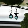 Asymmetrische handgemaakte vogeloorbellen met blauw glas en zwart gepatineerd koper