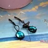 Asymmetrische handgemaakte vogeloorbellen met blauw glas en zwart gepatineerd koper