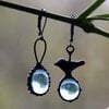 Asymmetrische handgemaakte vogeloorbellen met blauw glas en zwart gepatineerd koper