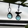 Asymmetrische handgemaakte vogeloorbellen met blauw glas en zwart gepatineerd koper