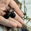 Asymmetrische handgemaakte vogeloorbellen met zwart glas en zwart gepatineerd koper