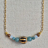 Gouden ketting half schakelketting half edelstenen met keramieken kraal