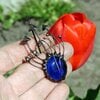 Handgemaakte paddenstoelenbroche met blauw glas en zwart gepatineerd koper