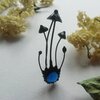 Handgemaakte paddenstoelenbroche met blauw glas en zwart gepatineerd koper