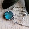 Handgemaakte paddenstoelenketting met blauw glas en zilverkleurig koper