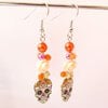 Halloween oorbellen met doodshoofdjes – vrolijke oranje en roze oorhangers