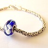 Handgemaakte donkerblauwe lampwork glasbedel met parelmoeren bloemen