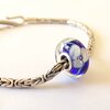 Handgemaakte donkerblauwe lampwork glasbedel met parelmoeren bloemen