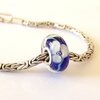 Handgemaakte donkerblauwe lampwork glasbedel met parelmoeren bloemen