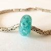 Handgemaakte turquoise lampwork glasbedel met luchtbellen en parelmoerglans