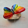 Regenboog vlinder van glas op steen