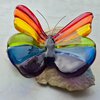 Regenboog vlinder van glas op steen