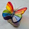 Regenboog vlinder van glas op steen