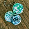 Aztec green Fotomedaillon ketting met drie verschillende verwisselbare voorkanten met close up foto`s in aqua blauw,mint groen en donkerblauwe tinten.