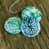 Aztec green Fotomedaillon ketting met drie verschillende verwisselbare voorkanten met close up foto`s in aqua blauw,mint groen en donkerblauwe tinten.