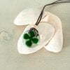 Glazen geluks hanger met klavertje vier. Inclusief antieke handelskraal.