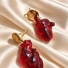 Goudkleurige ketting en oorbellen met rode hartjes