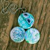 Roestvrij stalen fotomedaillon ketting met drie verschillende verwisselbare voorkanten met close up foto`s in aqua blauw. Rvs/roesvrij stalen fotomedaillon. Voor het dicht bij je dragen van je favoriete foto.