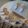 Romantisch & Botanisch, goudkleurige bloemen oorbellen met kristalhangers