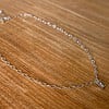 Zilverkleurige stainless steel ketting met lichtgrijze glazen bedel