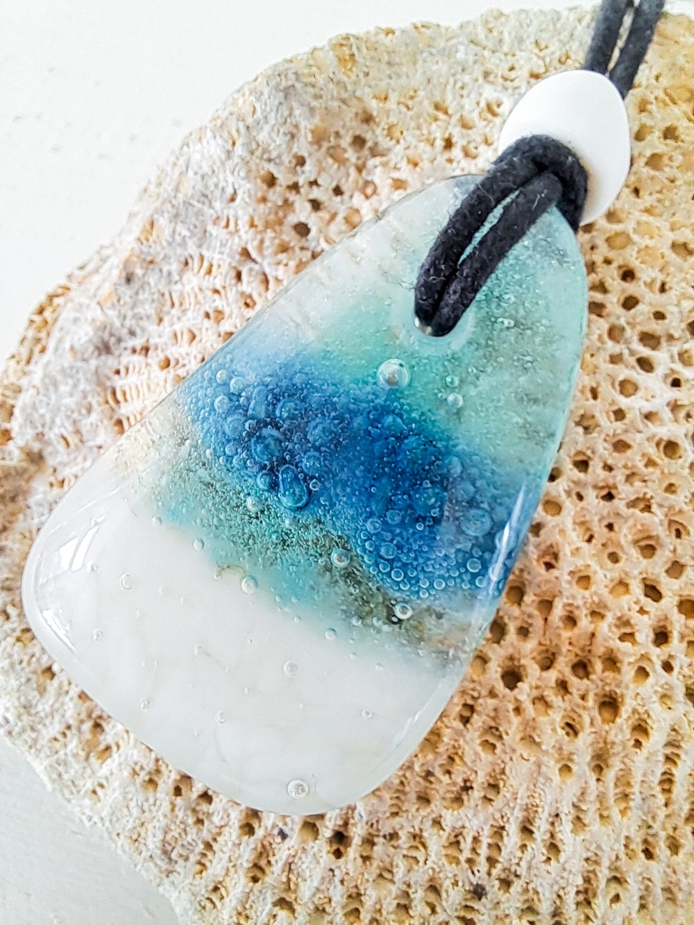 Handgemaakte hanger van versmolten glas in aqua turquoise blauw en wit,zeegezicht, inclusief antieke handelskraal enverstelbare ketting.