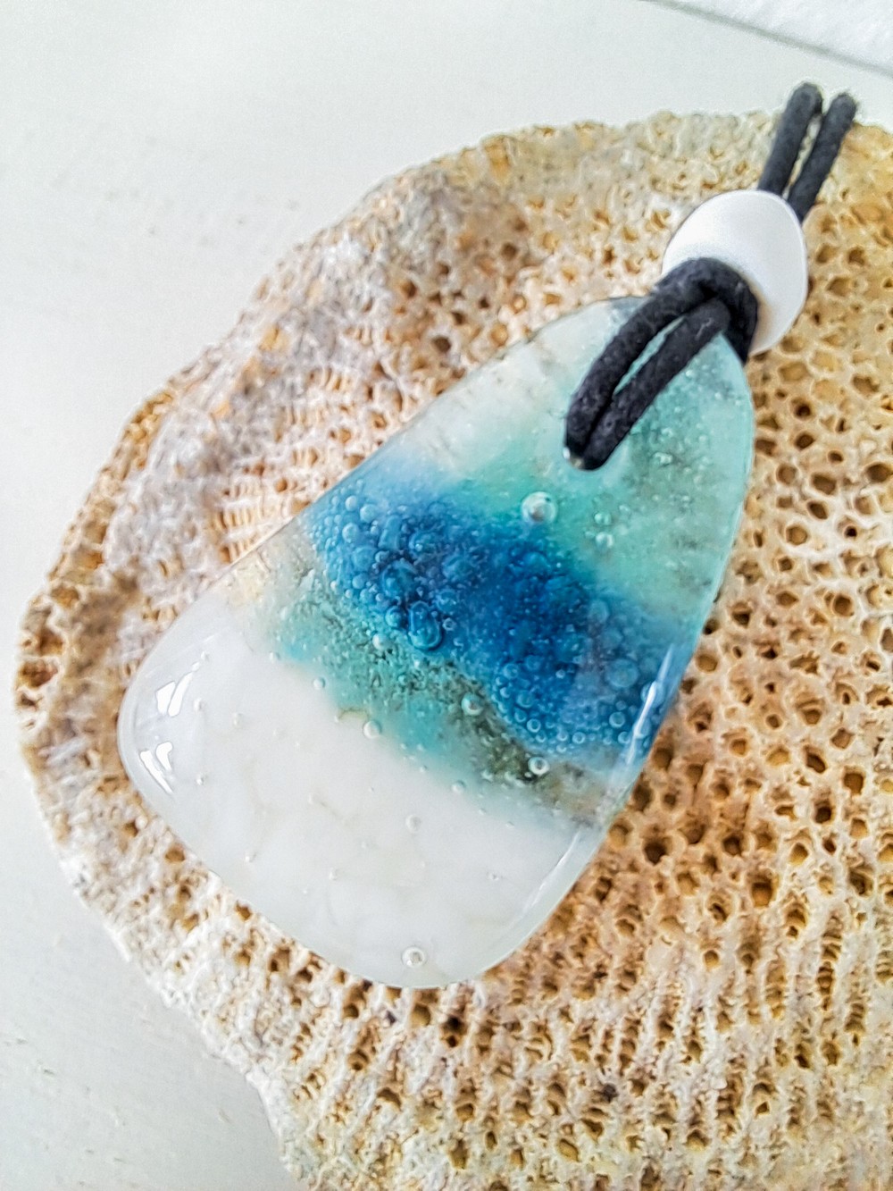 Handgemaakte hanger van versmolten glas in aqua turquoise blauw en wit,zeegezicht, inclusief antieke handelskraal enverstelbare ketting.