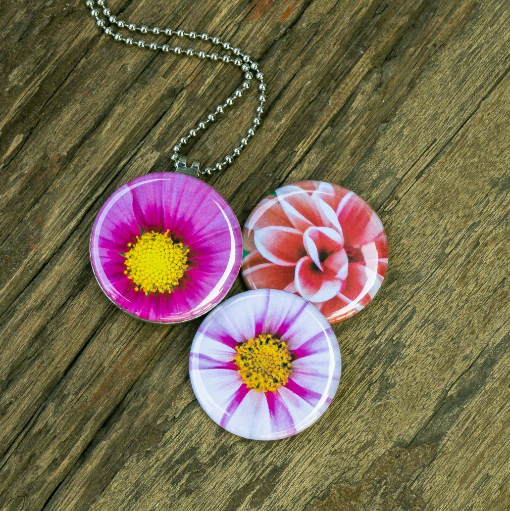 Roestvrij stalen fotomedaillon ketting met drie verschillende verwisselbare voorkanten met close up foto`s van roze,witte en zalm kleurige bloemen. Rvs/roestvrij stalen fotomedaillon. Voor het dicht bij je dragen van je favoriete foto.