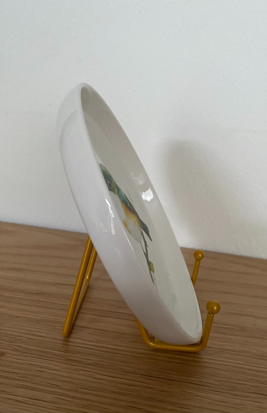 Vogel op een rond bordje met standaard.