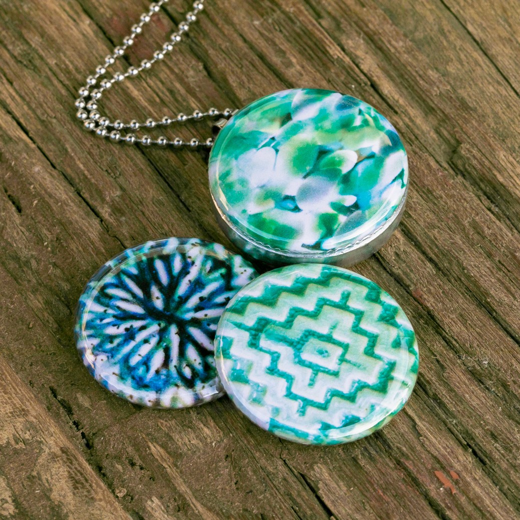 Aztec green Fotomedaillon ketting met drie verschillende verwisselbare voorkanten met close up foto`s in aqua blauw,mint groen en donkerblauwe tinten.Rvs/roestvrij stalen fotomedaillon. Voor het dicht bij je dragen van je favoriete foto.