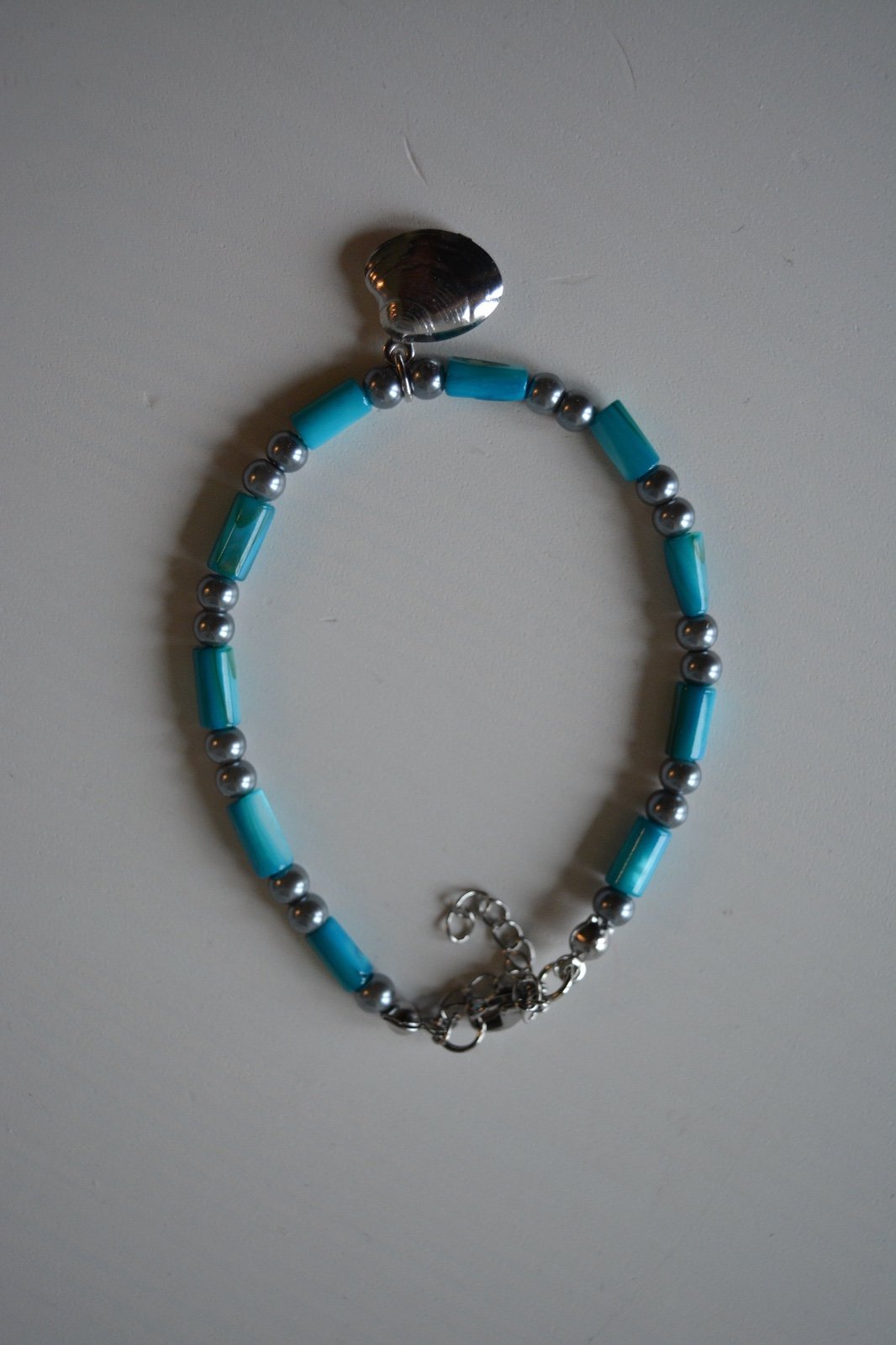 armbandje met schelpkralen en een schelpbedel