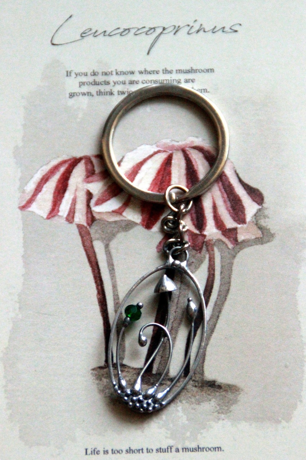 Handgemaakte paddenstoelensleutelhanger met groen glas en zilverkleur… - 145118 Handgemaakte paddenstoelensleutelhanger met groen glas en zilverkleurig koper