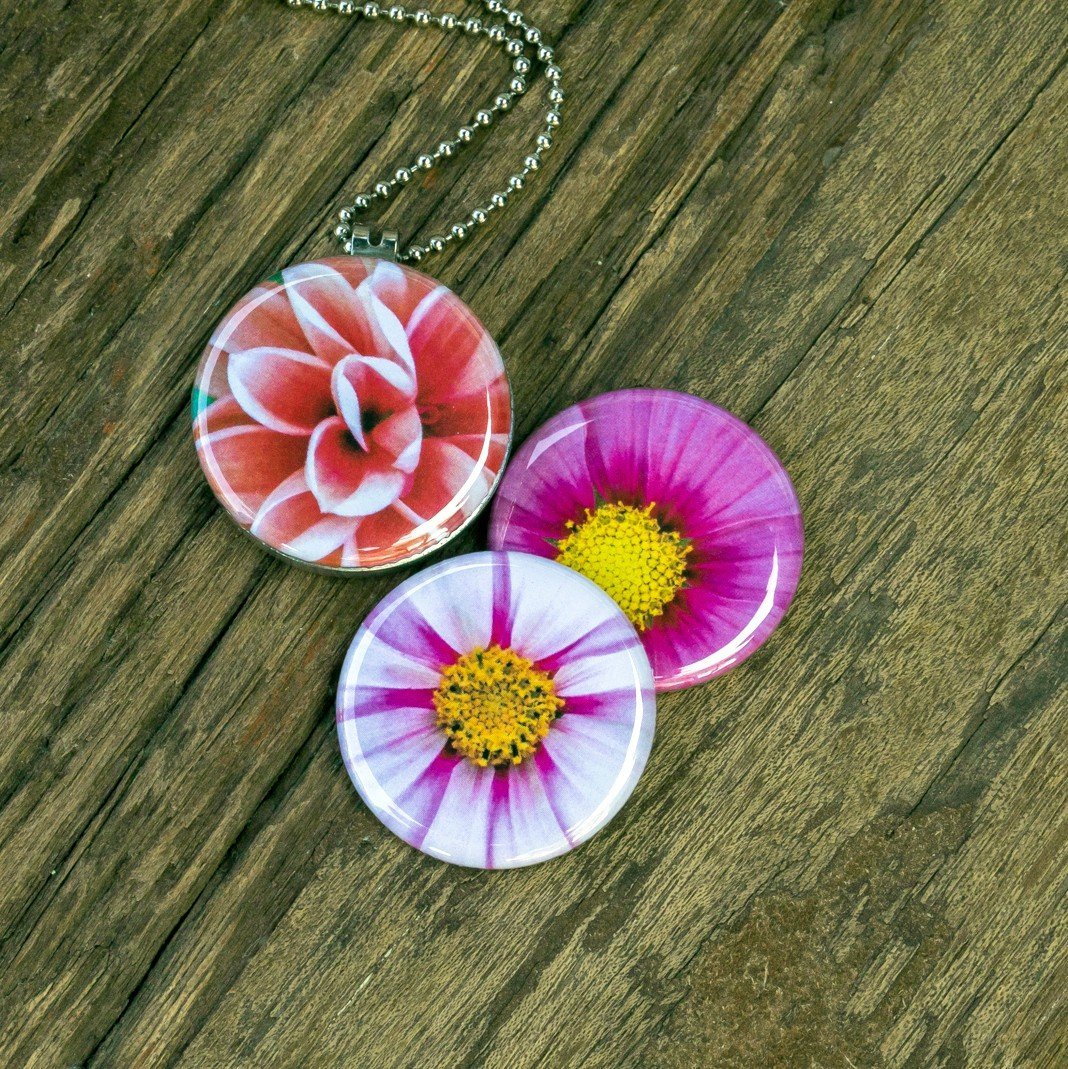 Roestvrij stalen fotomedaillon ketting met drie verschillende verwisselbare voorkanten met close up foto`s van roze,witte en zalm kleurige bloemen. Rvs/roestvrij stalen fotomedaillon. Voor het dicht bij je dragen van je favoriete foto.