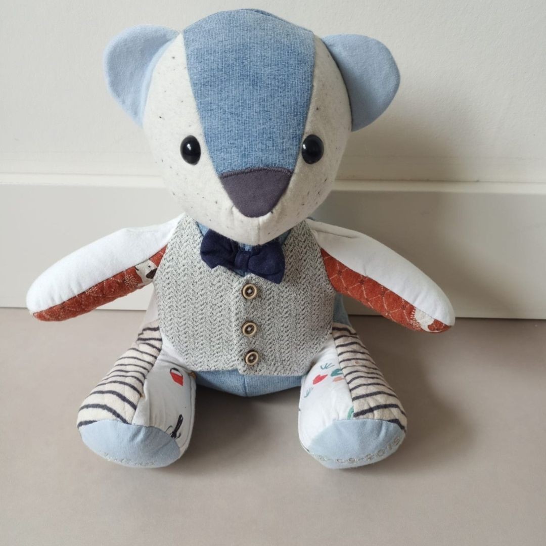 Herinneringsbeer van eerste babykleertjes