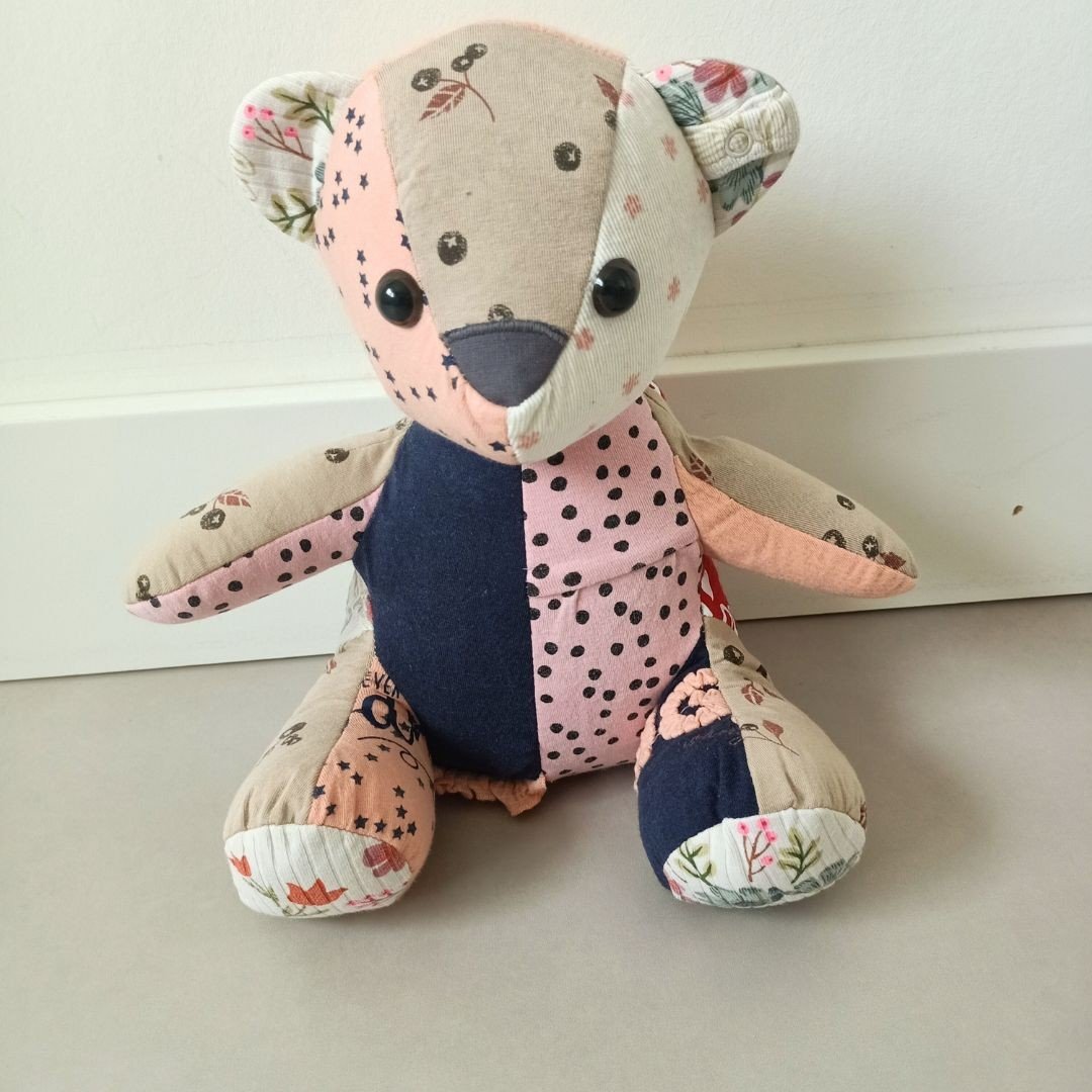 Herinneringsbeer van eerste babykleertjes