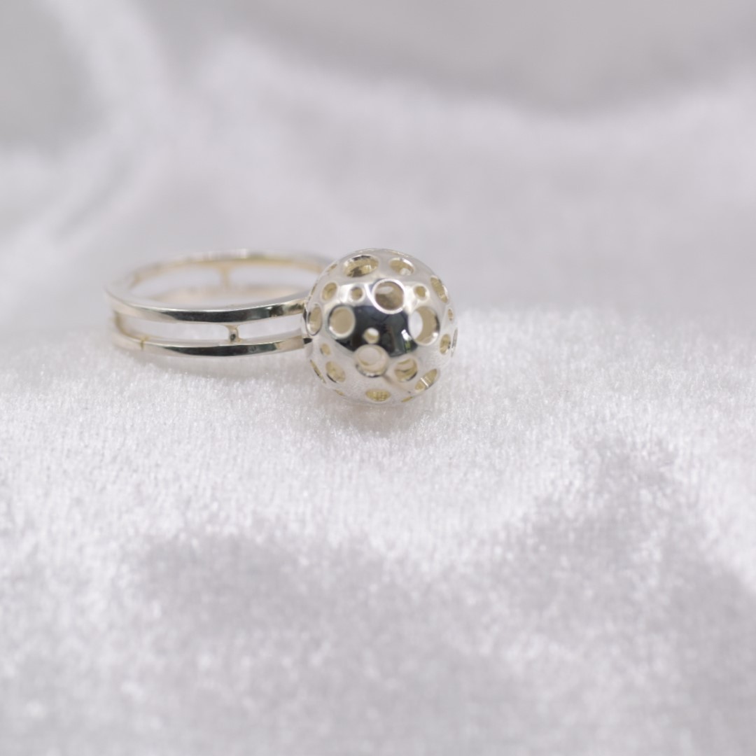 Unieke eyecatcher – zilveren ring met dubbel scheen en opengewerkte bal