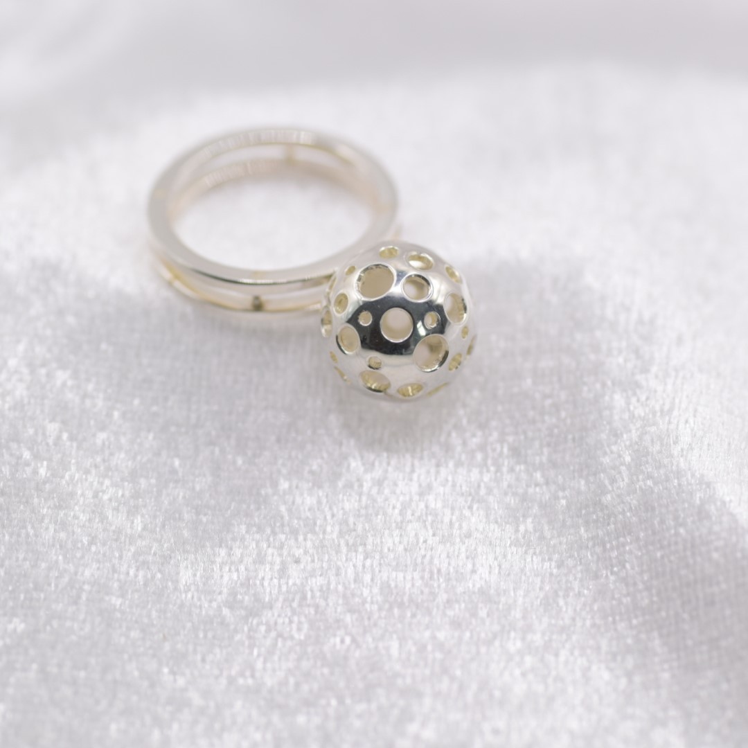 Unieke eyecatcher – zilveren ring met dubbel scheen en opengewerkte bal