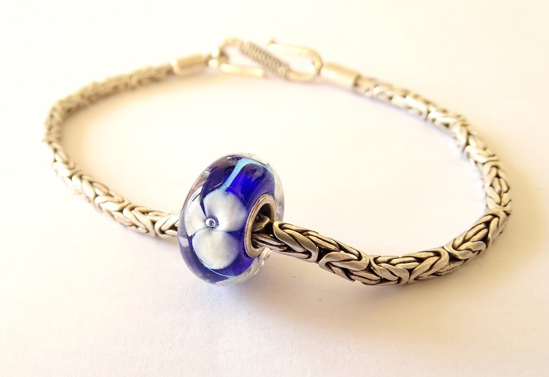 Handgemaakte donkerblauwe lampwork glasbedel met parelmoeren bloemen