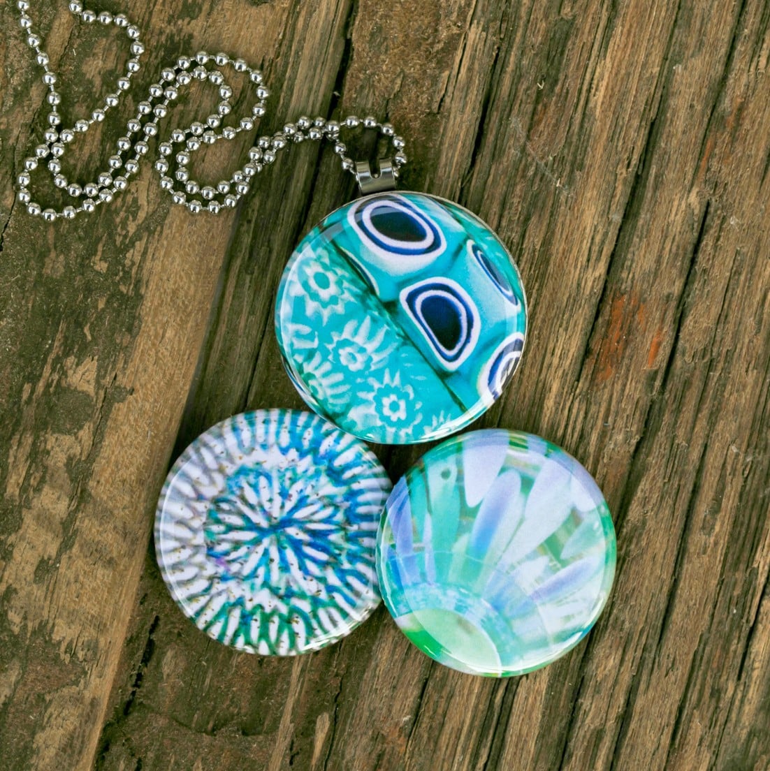 Roestvrij stalen fotomedaillon ketting met drie verschillende verwisselbare voorkanten met close up foto`s in aqua blauw. Rvs/roesvrij stalen fotomedaillon. Voor het dicht bij je dragen van je favoriete foto.