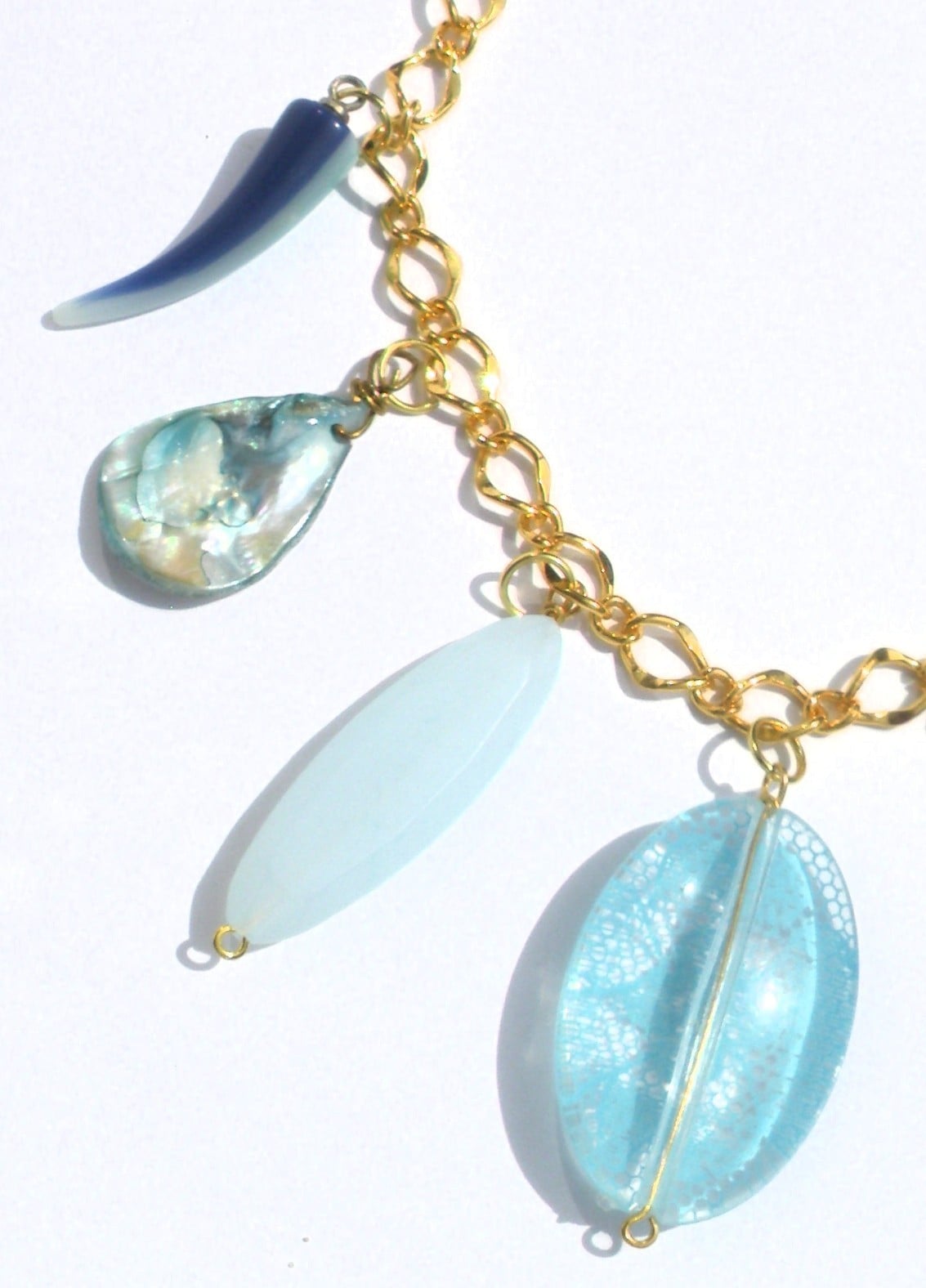 Goudkleurige schakelketting met hangers van schelp, parelmoer, kunsth… - 139216 Goudkleurige schakelketting met hangers van schelp, parelmoer, kunsthars en glas. Modieuze halsketting met turquoise bedel, Per Elle ketting