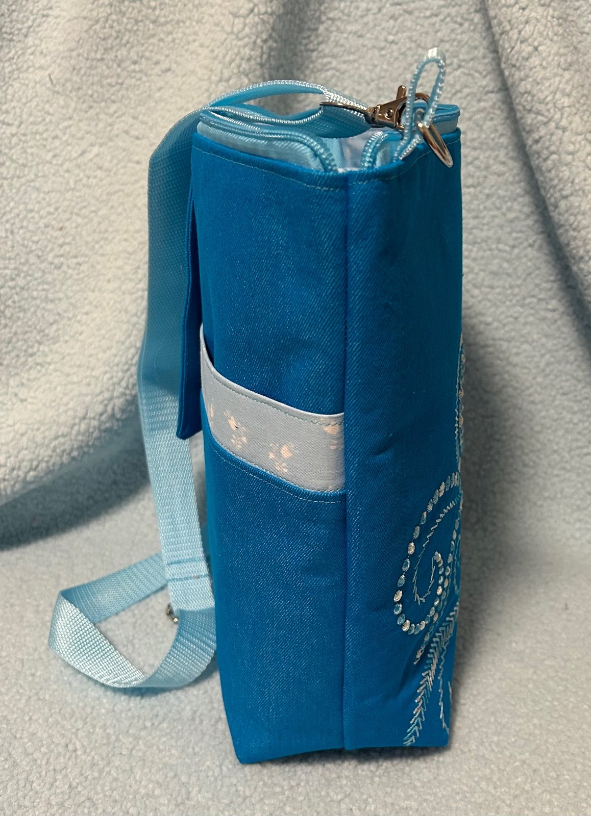 Schoudertas in aqua kleur met geborduurde fantasievogel.